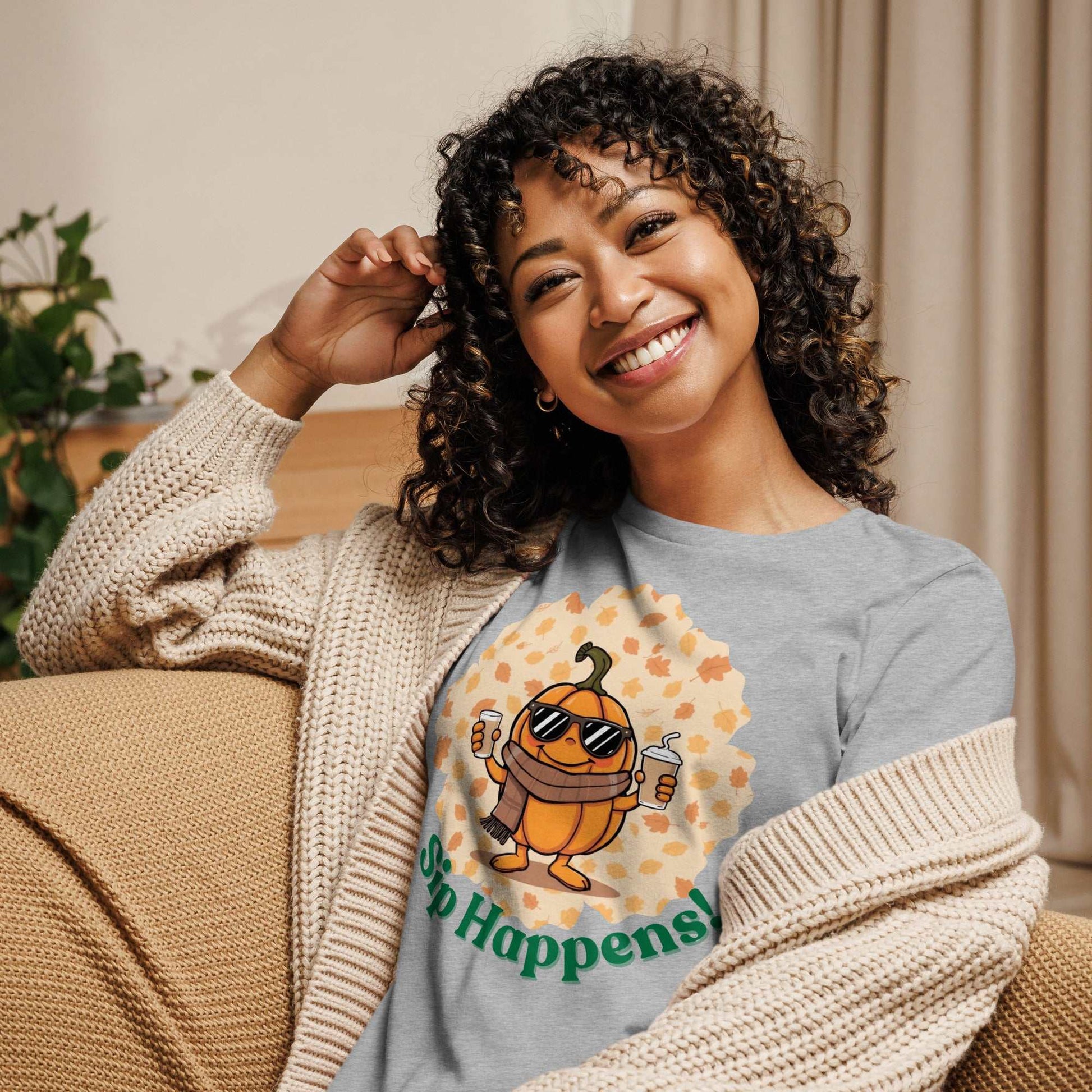 Image of a t-shirt with a cartoon pumpkin holding hot and cold Pumpkin Spice Latte T-Shirt, featuring the slogan "Sip Happens!" in playful font.